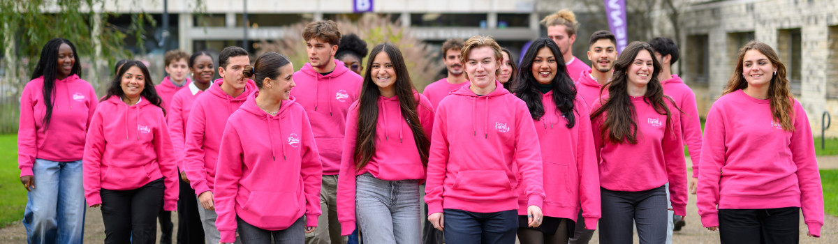Étudiants NEOMA habillés en rose, souriants, sortant du campus de Rouen