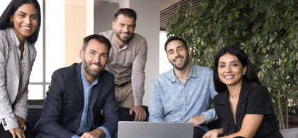 Équipe diversifiée en réunion qui sourie face caméra